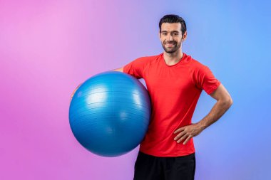 Vücut uzunluğunun tamamı atletik ve sportif genç bir adam tarafından izole edilmiş arka planda topu ayakta tutarken çekildi. Sağlıklı aktif ve vücut bakımı yaşam tarzı.