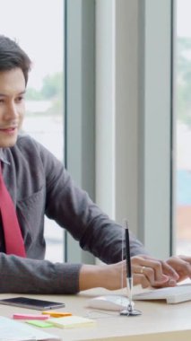 İki iş adamı toplantı odasında proje stratejisi hakkında konuşuyor. İş adamı, mali veri raporu hakkında sohbet ve tavsiyelerde bulunurken, modern işyerindeki iş arkadaşıyla proje planlamasını tartıştı.