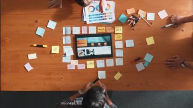 Web tasarımı için birlikte çalışan iş adamlarının üst düzey görüşü. Tasarımcı beyin fırtınası yapan ve web sitesi arayüzü hakkında tartışan ve dijital tasarım ile tablete bakan hava görüşü. Sempozyum.