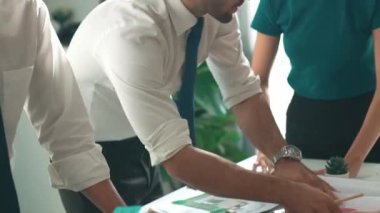 Akıllı iş adamlarının tasarımı planlamak için tabletten proje planına bakarken ve planlar ve toplantı masasındaki bina inşaatı hakkında tartışırken birlikte çalışması. Hizalama.
