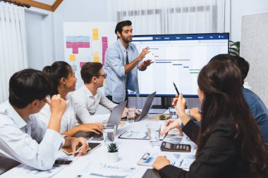 Proje yöneticisi monitörde proje yönetimi yazılım görüntülemesi, proje görevinin ilerlemesini izlemek ve toplantı masasında program planı yapmak suretiyle ekiple iletişim kurar ve işbirliği yapar. Tedbirli