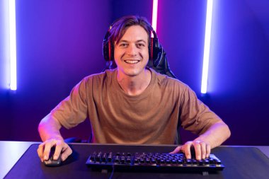 Kazanmak için çevrimiçi oyun oynayan akıllı flama makinesinin sunucu kanalı, neon ışıklı odada seçilen takım yarışması için izleyicilerle birlikte canlı yayında canlı yayında kulaklık takıyor. Bireysel.