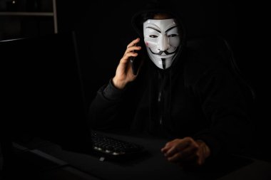 Beyaz gülümseyen isimsiz suçlu maskesi kurbana sesleniyor, kişisel bilgileri hacklemeye ikna ediyor, veri sunucu sistemindeki bilgisayar korsanlarının kullandığı şifreleme programını paylaşıyor. Tahmin et..