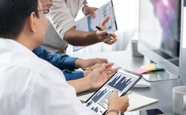 Veri analistleri ofis çalışanlarından oluşan bir ekip, tablet kullanarak finansal, trend ve pazarlama verilerini analiz etmek için iş istihbaratı BI gösterge paneli üzerinde işbirliği yapmaktadır. BI teknolojisi ve veri analizi kavramı. Tedbirli