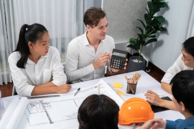 Mimari proje üzerinde birlikte çalışan çeşitli inşaat mühendisi ve müşteri grupları, planlar inşa etmek ve toplantı masasında inşaat projesi için risk azaltma hesapları yapmak. Tedbirli