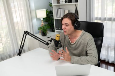 Sunucu kanalı, gülümseyen akıllı yayıncı kaydı, senaryosu ve akıllı telefonuyla sosyal medyada sohbet programı, kulaklık takarak modern ev stüdyosundaki video flamalarını kaydediyor. Bireysel.