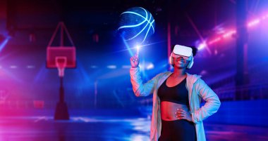 Basketbolcu, basketbol hologramını fütüristik spor sahasında tutuyor. Artırılmış gerçeklik teknolojisi kullanarak basketbol becerisi geliştiren enerjik sporcu ya da sporcu. Yenilik. Yaratıcılık..