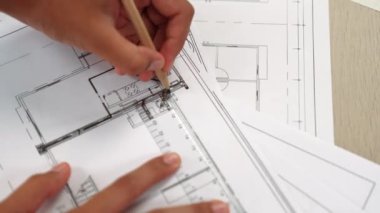 Ölçüm aracı ve kalem el kullanan akıllı mimar veya akıllı mühendisin videosu mimari ofisteki inşaat hatasızlığı için ayrıntılı bir tasarım hazırladı. Eline odaklan. - Yakın çekim. Tanımlama.