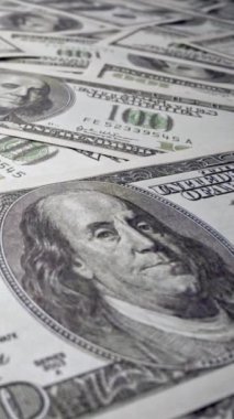 Ofis masasında 100 dolarlık kağıt para yığını. Maliye ve para ödemesi kavramı.