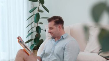 Kanepede oturan orta yaşlı bir adam, sosyal ve teknolojik mesleki gelişmeler hakkında ders kitabı okur ya da çocukları iyi bir yetişkin baba olmak için yetiştirir. Hayat boyu öğrenme konsepti. Uyumsuzluk.