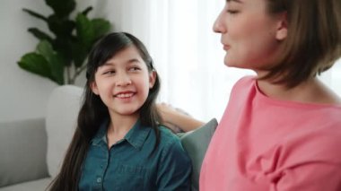 Mutlu anne oturma odasında otururken kızıyla deneyim paylaşıyor. Kafkas anne ve mutlu çocuk konuşuyorlar ve birlikte vakit geçiriyorlar. Çekici kız gülümserken ebeveyn hikayesini dinler. Pedagoji.