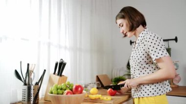 Çekici beyaz anne salata yapmak için taze sebze doğruyor. Mutlu enerjik akıllı anne kahvaltıda sağlıklı yemek pişirirken modern mutfakta çalışıyor. Yemek hazırlama konsepti. Pedagoji.