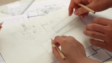 Mimari ekipmanlarla toplantı masasında ev tasarımı üzerine profesyonel mühendis ekibi tartışması ve modern ofiste bina planı dağılımı. Eline odaklan. - Yakın çekim. Tanımlama.