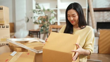 Genç girişimci, karton kutularda paketleme yapıyor ve paket etrafa saçılıyor. Çekici çevrimiçi satıcı paket taşıyor ve teslimat ve nakliye siparişine hazırlanıyor. Myrmidon.