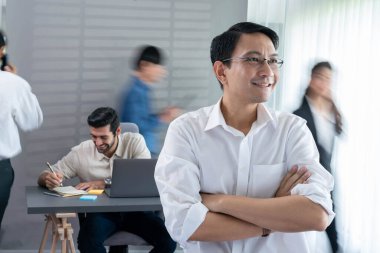 Ofiste çalışan iş arkadaşı ve iş adamlarının bulanık hareketli geçmişine sahip güler yüzlü iş adamı portresi. Ofis çalışanı takım çalışması ve pozitif iş yeri konsepti. Tedbirli