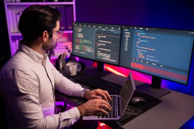 Akıllı IT geliştiricisi, yazılım kodlama sisteminde Neon Light ofis odasında yazı yazmak için çalışıyor, uygulama programı güncellemesi en son online web sitesi veritabanını çevrimiçi yapıyor. Tahmin et..