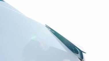 Yakındaki adam, şehir merkezinin otoparkındaki şarj istasyonundan elektrik aküsünü şarj etmek için EV şarj aleti taktı.