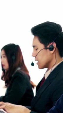 Ofiste çalışan kulaklık takan işadamları uzak müşteri ya da meslektaşlarını desteklemek için çalışıyorlar. Arama merkezi, tele pazarlama, müşteri destek acentesi telefon görüşmesinde hizmet sunar.