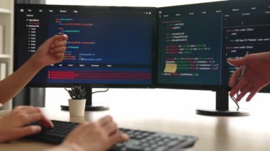 Yavaş çekim arkası yazılım geliştirici mühendisi bilgisayar programlama için birlikte çalışarak hata ayıklama kodunu çözüyor, ofiste monitörde karmaşık algoritmaları çözüyor. Filizlenen