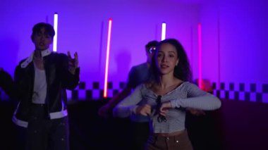 Kameranın önünde dans eden yetenekli break dansçı farklı arkadaşları pop ya da hip hop müziği dinlemek için arkada dans ediyor. Çekici performans ekibi kameraya doğru hareketli hareketler sergiliyor. Mutluluk.