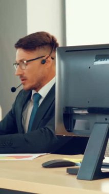 Ofiste çalışan kulaklık takan işadamları uzak müşteri ya da meslektaşlarını desteklemek için çalışıyorlar. Arama merkezi, tele pazarlama, müşteri destek acentesi telefon görüşmesinde hizmet sunar.