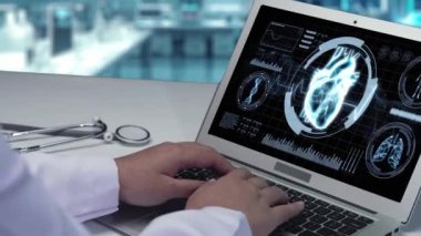 Doktorun bilgisayarda insan kalbi anatomisi olan bilgisayara yazıp baktığı bilgisayarın arka planı bulanık. Sağlık çalışanı kalp ameliyatına hazırlanıyor. İyileştirici.