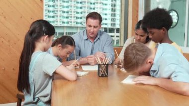 Sıradan tişörtlü zeki liseli çocuk, karışık ırkları olan öğrenciler kitap yazarken profesyonel öğretmene soruyor. Yaratıcı çocuk notayı işaret ederken Kafkas eğitmeni yorum yapıyor. Öğretim