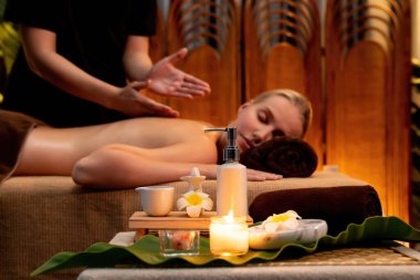 Aromaterapi masajı ambiyansı ya da spa salonu kompozisyon düzeneği bulanık kadınlara odaklı dekor mumları ve spa aksesuarları ile tatil köyü veya otel arka planında keyifli aroma spa masajı yapan. Sessiz.