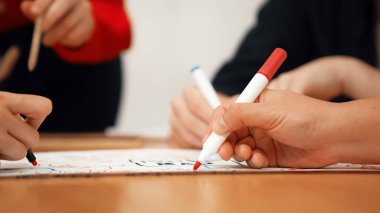 Yetenekli iş adamlarına yakın çekim yapmak beyin fırtınası yapmak, birlikte çalışmak, toplantı masasında zihin haritası ve renkli kalemler kullanarak pazarlama fikrini tartışmak. Eline odaklan. Tertemiz..