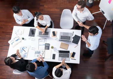 Üst düzey ofis çalışanları stratejik iş pazarlama toplantısı üzerine anlaşma yaptıktan sonra el sıkışıyor. Takım çalışması ve olumlu tutum verimli ve destekleyici bir iş yeri yaratır. Tedbirli
