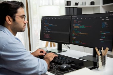 Akıllı IT geliştiricisi yazılım geliştirme kodlaması ile modern ofisteki iki bilgisayar kodlu bilgisayar sistemi üzerinde uygulama programı güncelleme çevrimiçi web sitesi yaratıyor. Tahmin et..