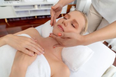 Kafkasyalı kadın stres önleyici kafa masajından ve lüks tatil beldesi ya da otel spa salonundaki modern ışık ortamında yüz güzelliği eğlencelerini şımartmaktan hoşlanıyor. Sessiz.