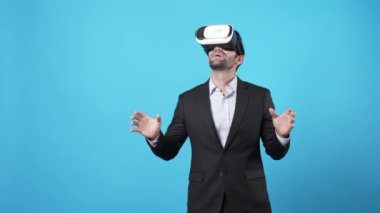 Finansal rapor hologramına bakarken finansal verileri yöneten akıllı bir proje yöneticisi. Yetenekli iş adamı elini hareket ettiriyor ve mali tablolara bakarken mavi arka planda duruyor. Aygıt.