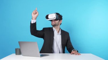 İş adamı bilgisayarla masada oturmuş yaratıcı fikirleri tartışıyor ve arttırılmış gerçeklik teknolojisi kullanarak online toplantıya katılıyor. Proje yöneticisi pazarlama stratejisini sunuyor. Aygıt.