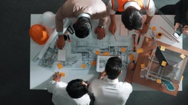 Becerikli mühendis ekibinin ev inşaatından bahsedişinin en alt görüntüsü. Mimar ya da tasarımcı grubunun planlar hakkında beyin fırtınası yapmak için tartışan ve yazan hava görüşü. Hizalama.