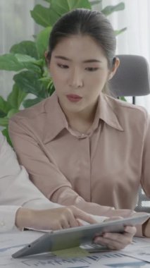 Ofis çalışma alanında birlikte çalışan iki genç hevesli iş kadını. Genç meslektaşlar tartışırken ve dizüstü bilgisayar kullanırken. Modern ofis çalışanları masada birlikte oturuyorlar..