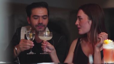 Akıllı bir çift, martiniyle kadeh kaldırıyor zeytinli martini ve margarita tatlandırıcı lezzetli sohbet grubundaki arkadaşlarıyla gece kulübünde keyif çatıyor. Vinosity.