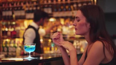 Oturan güzel bayan misafirin canı sıkılıyor. Arkadaşlarını beklemekten ya da barmenlerin arka planındaki lüks tezgah barında karışık votka içmekten sıkılıyor. Vinosity.