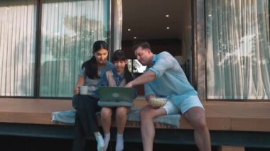 Şirin baba, anne ve kızı birlikte evin bahçesinde oturuyorlar. Ebeveynler, çevre farkındalığıyla ilgili genç nesli iletişim kurmak için açık hava aktivitelerini kullanırlar. Uyumsuzluk.