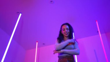 Latin dansçıların kameraya bakıp şehrin pop müziğiyle dans ettiği düşük açılı kamera. Profesyonel çekici hipster, mor veya neon ışıklı hip hop şarkısına geçiyor. Şık bir kumaş. Mutluluk.