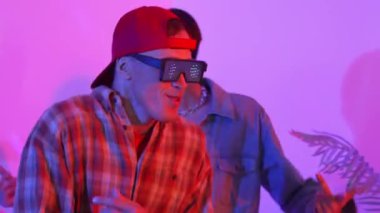 Break dansçı takımının modern stüdyoda pembe ışıkla dans etmesini kapatın. Çok kültürlü insanlar moda kıyafetleri giyerek hip hop müziğine geçiyorlar. Çılgın, komik bir ruh hali. Mutluluk.