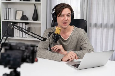 Akıllı yayın kanalının sunucusu kamerayla kayıt yapıyor sosyal medyada canlı yayın yapıyor, sosyal medyada yayın yapıyor, kulaklık takıyor ve modern stüdyoda video kaydediyor. Bireysel.