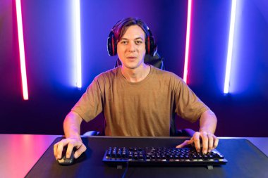 Kazanmak için çevrimiçi oyun oynayan akıllı flama makinesinin sunucu kanalı, neon ışıklı odada seçilen takım yarışması için izleyicilerle birlikte canlı yayında canlı yayında kulaklık takıyor. Bireysel.