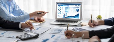 İş zekası ve veri analizi kavramı. Analizci ekibi laptop ekranında finansal veri analizi üzerinde çalışıyor. Etkili iş stratejik planlama için pazarlama göstergesi olarak. İçgörü