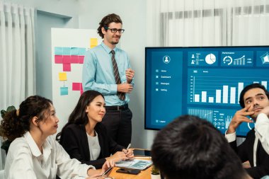 İş adamı, finansal rapor veri analizi veya pazar eğilimi gösterisiyle iş sunumunu şirketin gelecekteki yönetiminde stratejik planlama için büyük bir TV ekranında sundu. Habiliment