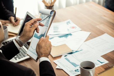 Ofis masasındaki finansal veri raporlarını analiz eden çeşitli bir grup iş analisti. Stratejik pazarlama planlaması için iş zekası analizi çizelgesi ve grafiği.