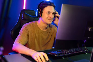 Kazanmak için çevrimiçi oyun oynayan akıllı flama makinesinin sunucu kanalı, neon ışıklı odada seçilen takım yarışması için izleyicilerle birlikte canlı yayında canlı yayında kulaklık takıyor. Bireysel.