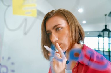 Kafkas iş dünyasının genç ve güzel liderinin kapanışı, pazarlama fikrini cam tahtaya zihin haritası ve renkli yapışkan notlarla yazarken sunuyor. Portre. Beyin fırtınası. Tertemiz..