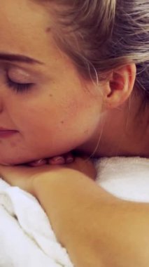 Spa yatağında uzanan rahat genç bir kadın lüks bir spa merkezinde yüz bakımı ve masaj için hazırlandı. Sağlık, stres atma ve gençleştirme kavramı.