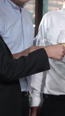 Başarılı iş adamları balo salonunda takım arkadaşlarıyla şarap ve şampanya içerek yeni ürünleri piyasaya sürme projesini kutluyorlar. Kurumsal iş ve insan ağ kurma kavramı.